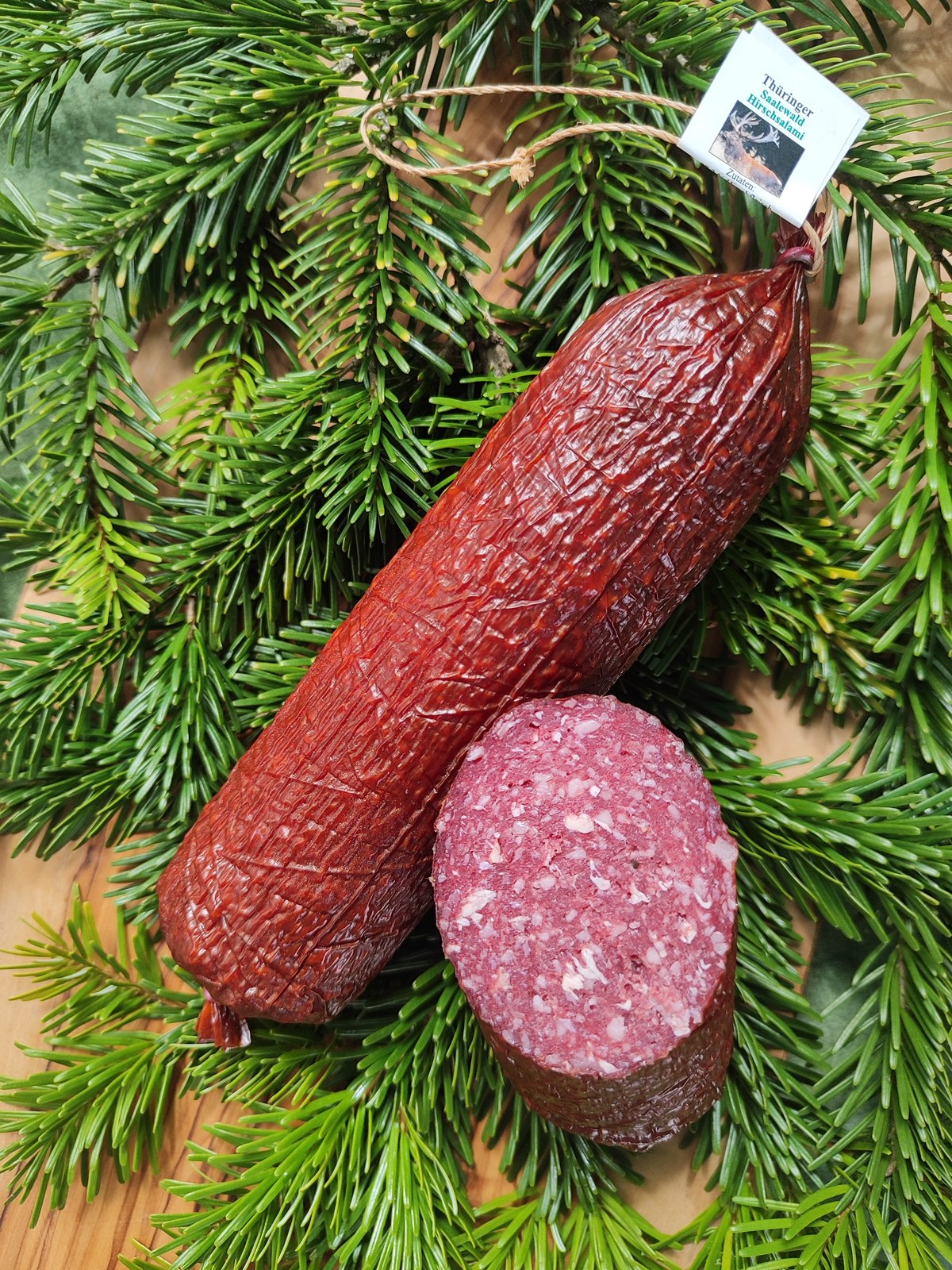 Hirschsalami vor Tannengrün arrangiert