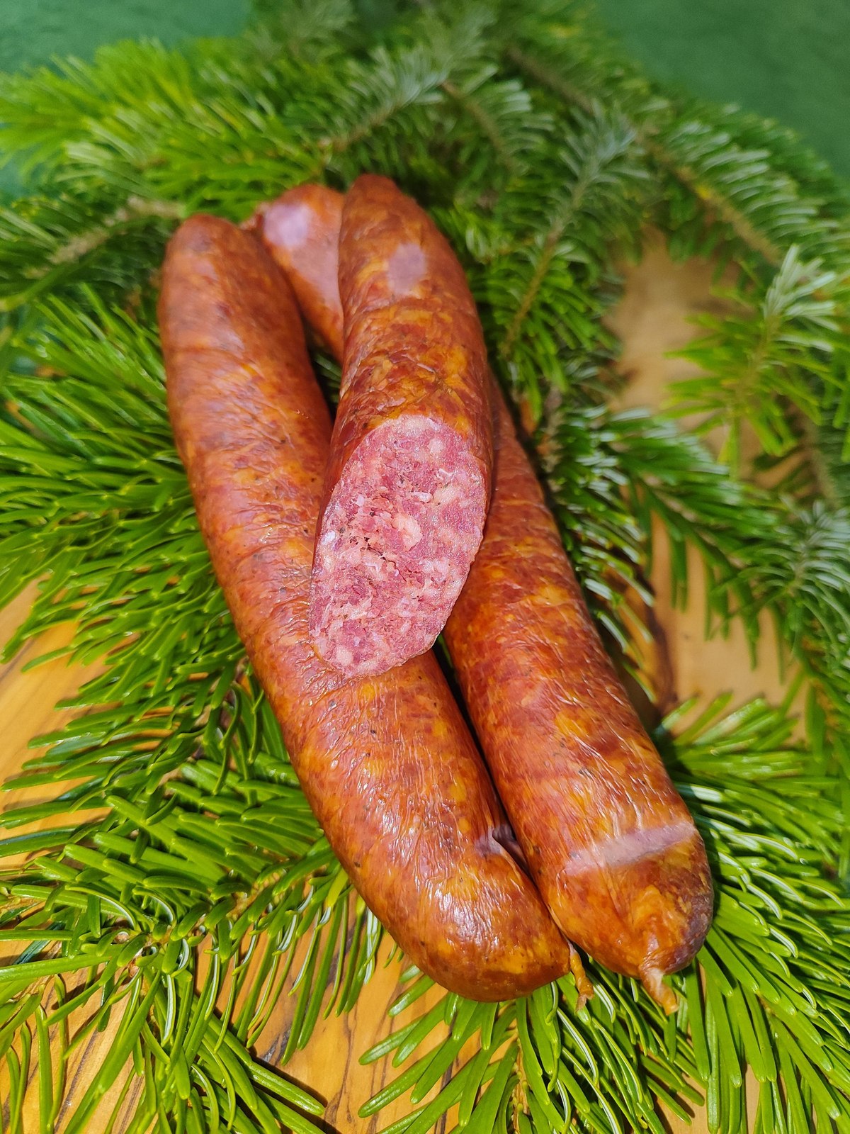 Wildräucherbratwurst kalt geräuchert im Ring auf Tannengrün
